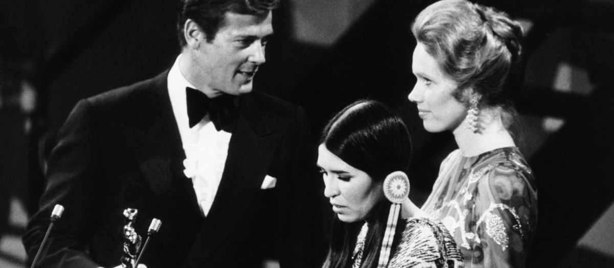 La indígena norteamericana Sacheen Littlefeather rechaza el Oscar de Marlon Brando que le ofrecen Roger Moore y Liv Ullman