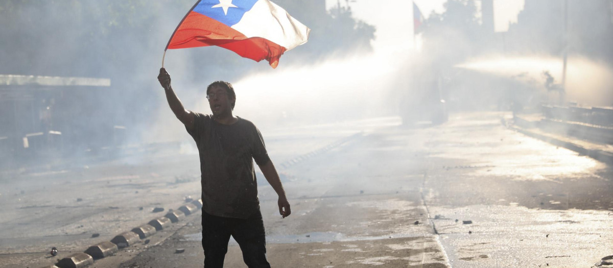 Un hombre ondea una bandera de Chile en las calles de su capital, Santiago de Chile