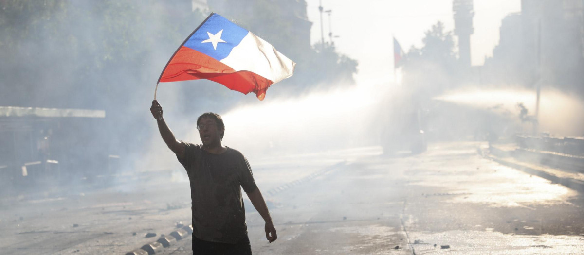 Un hombre ondea una bandera de Chile en las calles de su capital, Santiago de Chile