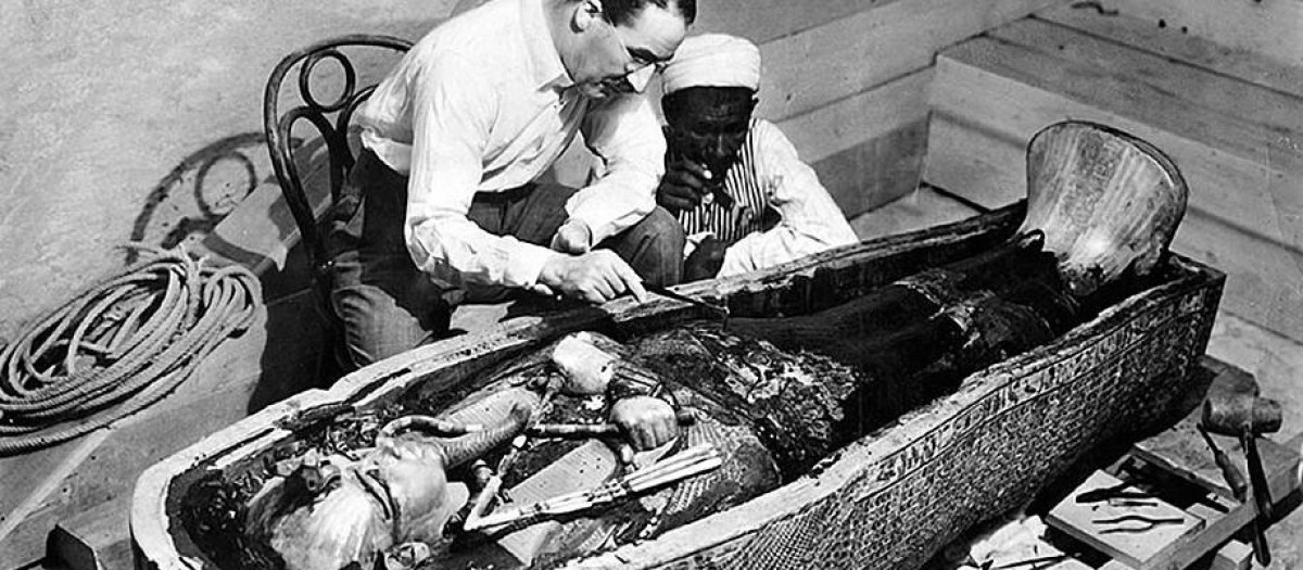 Howard Carter examina la tumba de Tutankamón junto a un egipcio anónimo