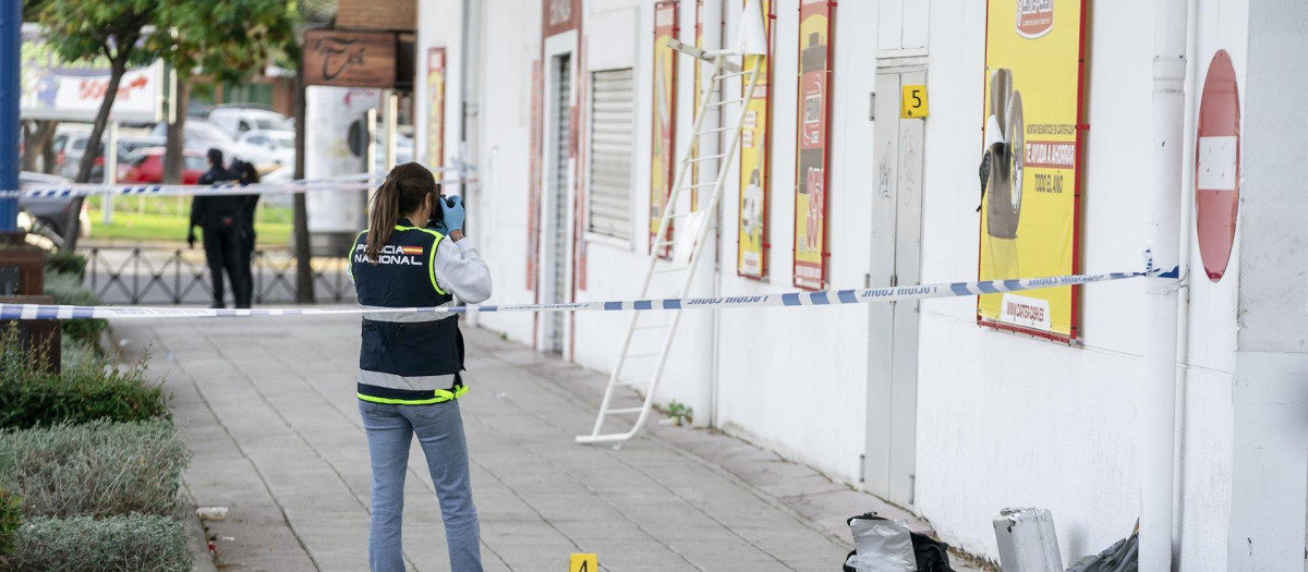 Una policía inspecciona el lugar donde fue asesinado un joven dominicano en Fuenlabrada.