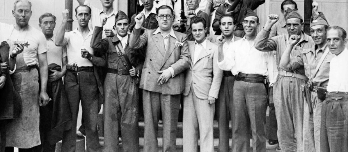 El jefe de la Milicia Popular de Investigación, Agapito García Atadell, (con gafas), saluda puño en alto acompañado de algunos de los milicianos que trabajan a sus órdenes