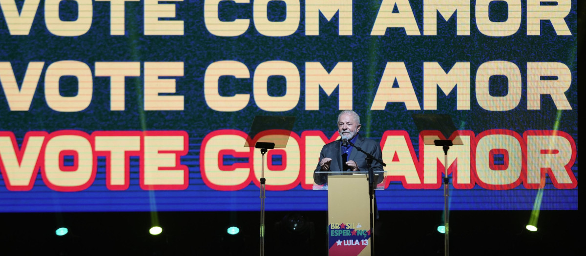 Wih a screen with text that reads in Portuguese "Vote with Love," Brazil's former President Luiz Inacio "Lula" da Silva, who is running for reelection, speaks during a meeting with artists in Sao Paulo, Brazil, Monday, Sept. 26, 2022. Brazil's general elections are scheduled for Oct. 2. (AP Photo/Andre Penner)