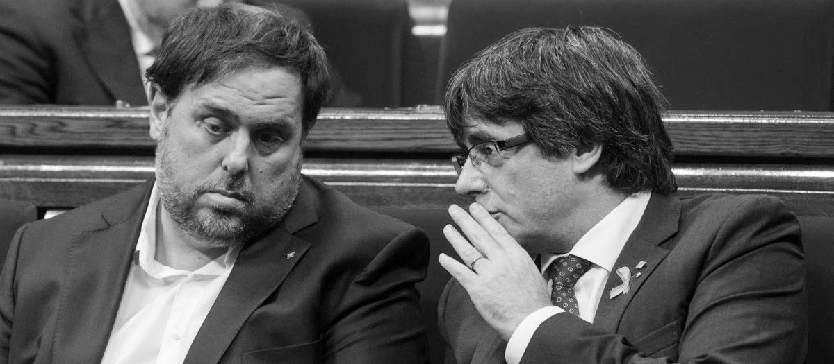 El presidente de la Generalitat, Carles Puigdemont (d) conversa con el vicerpresidente del Govern y conseller de Economía, Oriol Junqueras
