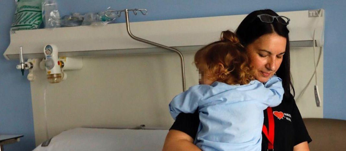 Una voluntaria de Mamás en Acción con una niña en brazos