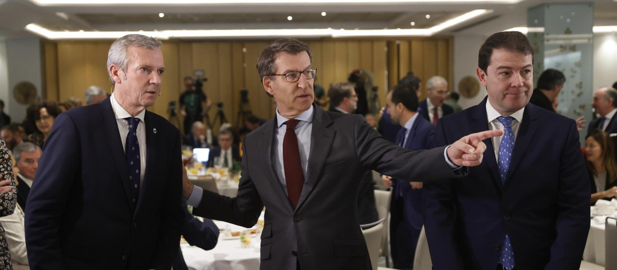 El líder del PP, Alberto Núñez Feijóo (c), durante el desayuno informativo en el que ha presentado la intervención del presidente de la Xunta de Galicia, Alfonso Rueda (i), este martes en Madrid, acompañado del presidente de Castilla y León, Alfonso Fernández Mañueco