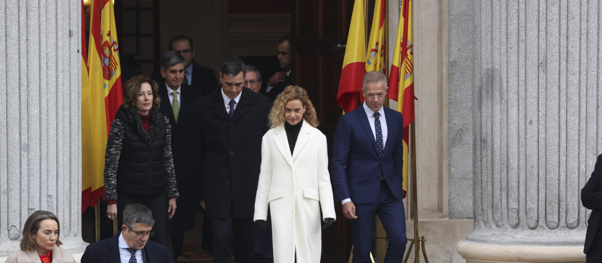 Meritxell Batet y Pedro Sánchez saliendo por la puerta de los leones