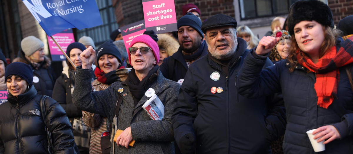 Supporters of nurses' strike and NHS shout slogans at a picket line outside St Mary's Hospital in west London on December 15, 2022. - UK nurses staged an unprecedented one-day strike as a "last resort" in their fight for better wages and working conditions, despite warnings it could put patients at risk. (Photo by ISABEL INFANTES / AFP)