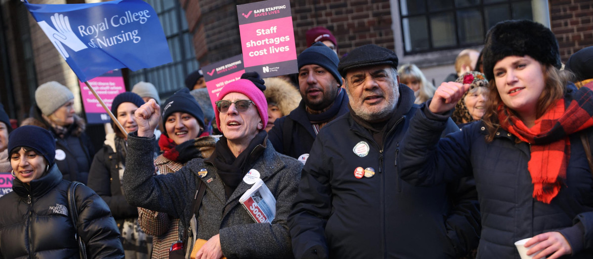 Supporters of nurses' strike and NHS shout slogans at a picket line outside St Mary's Hospital in west London on December 15, 2022. - UK nurses staged an unprecedented one-day strike as a "last resort" in their fight for better wages and working conditions, despite warnings it could put patients at risk. (Photo by ISABEL INFANTES / AFP)