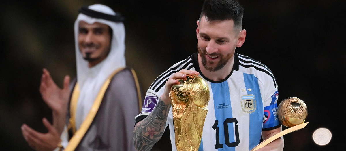 Argentina mira la Copa del Mundo mientras sostiene el trofeo al Mejor Jugador del Torneo