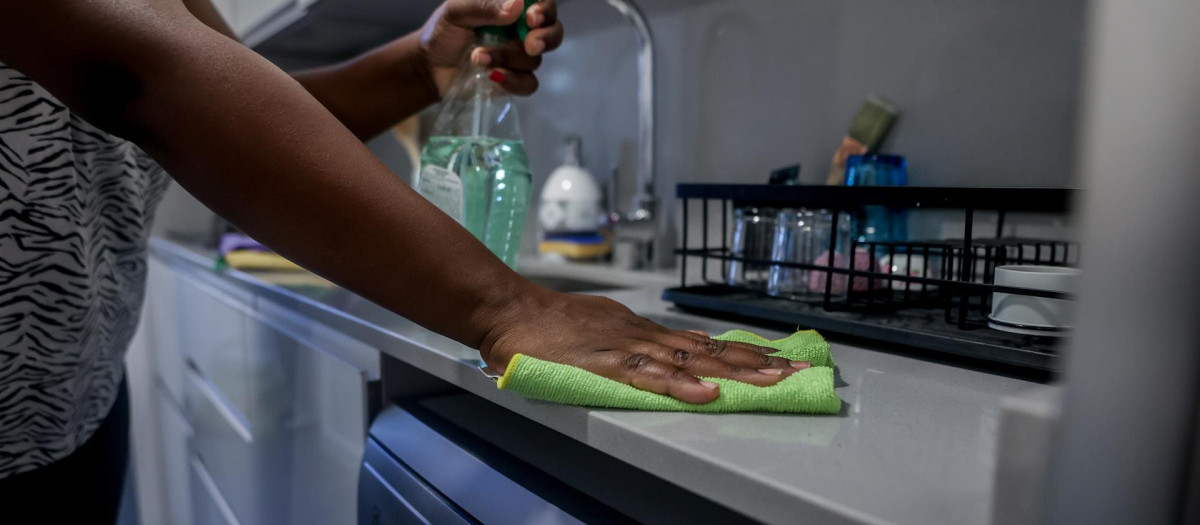 Una empleada del hogar limpia la cocina