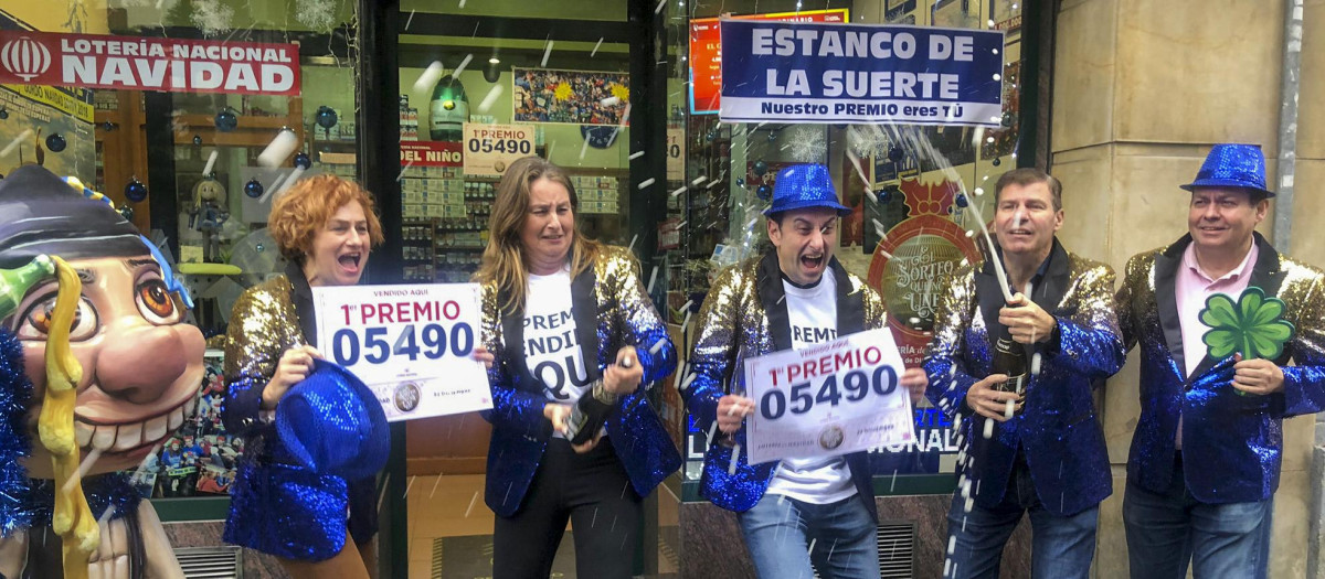 Responsables de la administración de lotería de la calle Jovellanos, número 8, de Oviedo, celebran la venta de un décimo del Gordo de Navidad