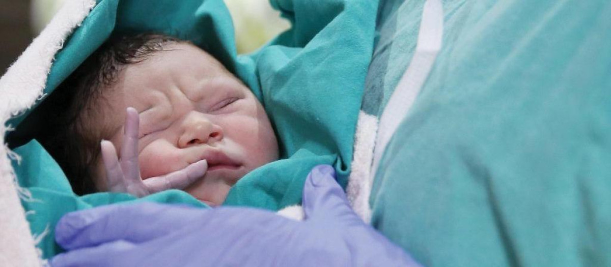 Imagen de un recién nacido con una matrona