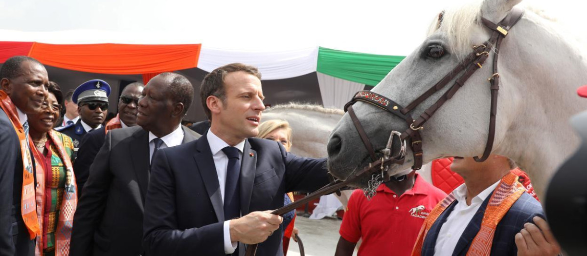 El presidente de Francia, Emmanuelle Macron, acaricia al caballo que le regalaron en su viaje a África