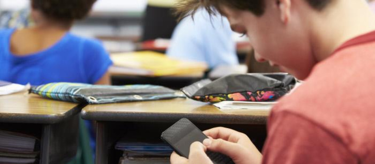 Un estudiante usa el móvil durante una clase