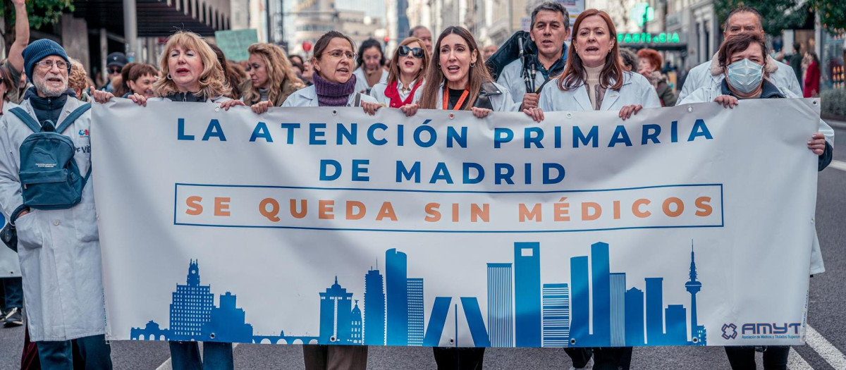 Varias personas caminan llevando una pancarta que reza 'La atención primaria de Madrid se queda sin médicos' durante una manifestación de médicos y pediatras