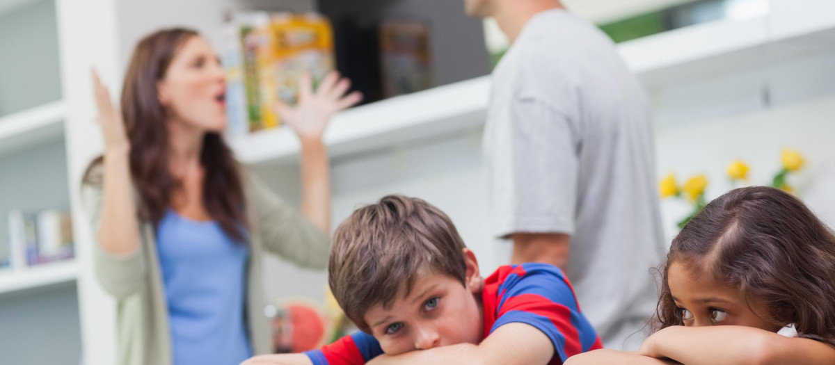 Padres discutiendo detrás de sus hijos en la cocina
