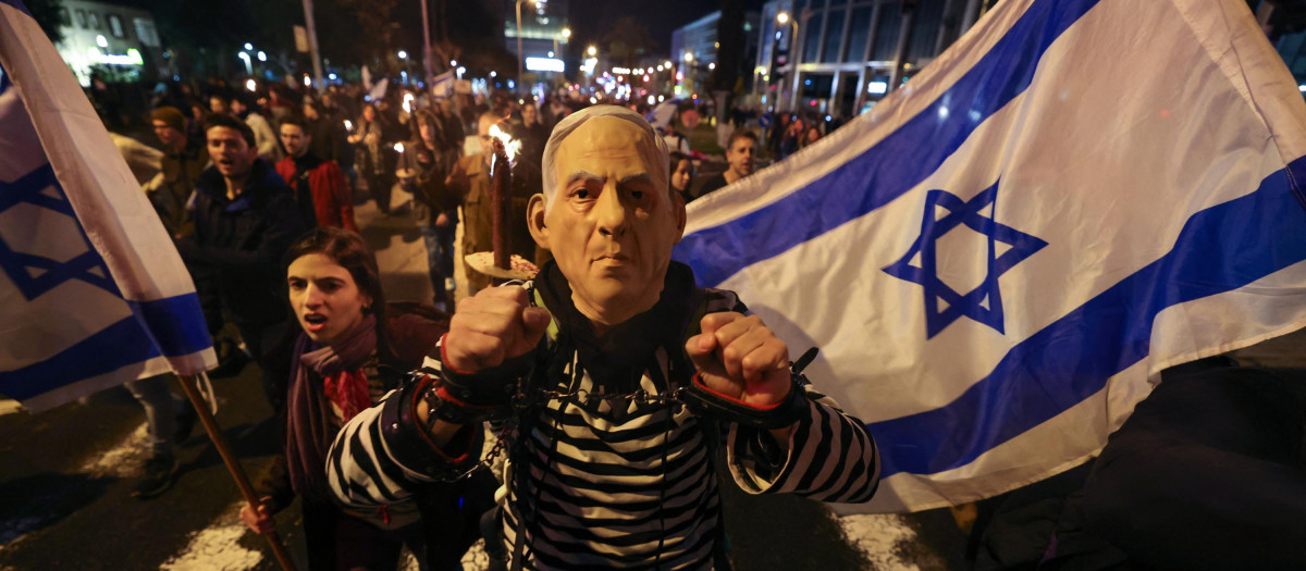 Un israelí con una máscara del primer ministro Benjamín Netanyahu protesta en Tel Aviv