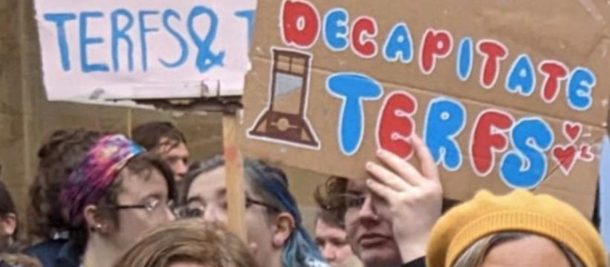 Imagen de las políticas escocesas bajo los carteles donde se pide decapitar a las TERFS