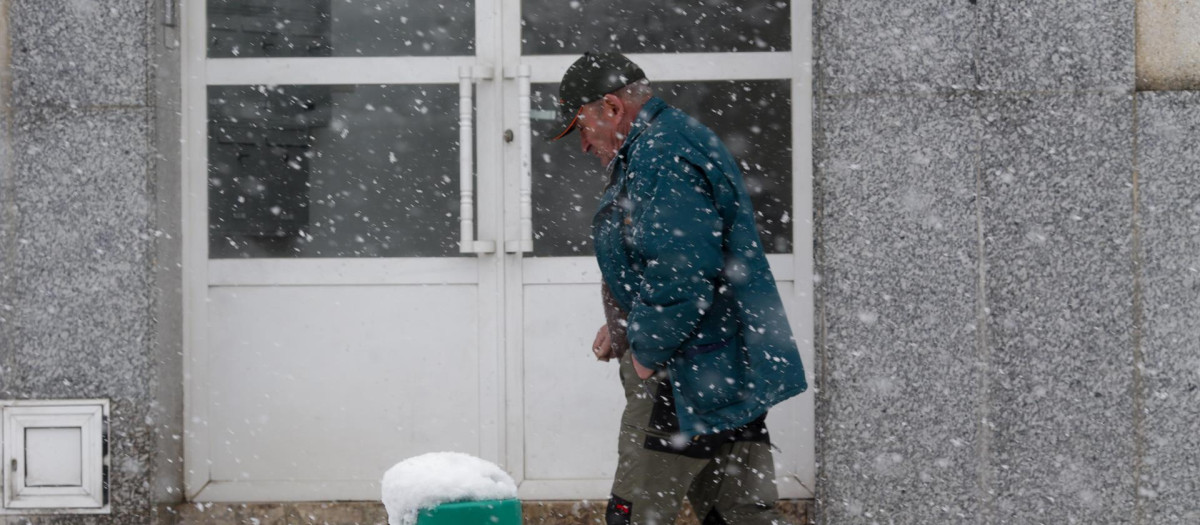 Un hombre camina por una calle cubierta de nieve