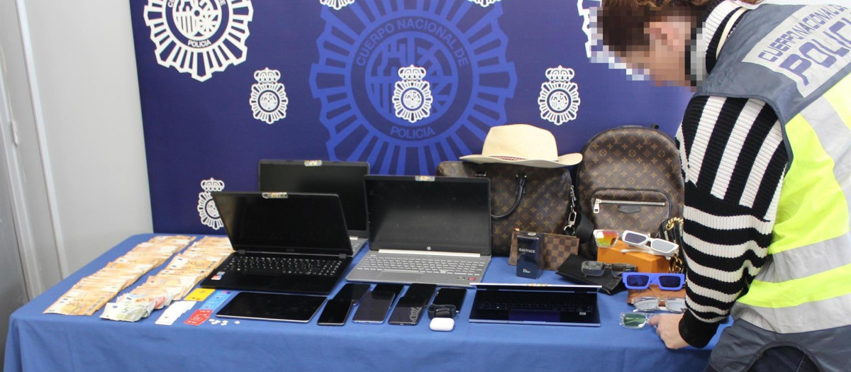 Dinero y equipos incautados por la Policía durante una redada contra un grupo de estafas mediante smishing.