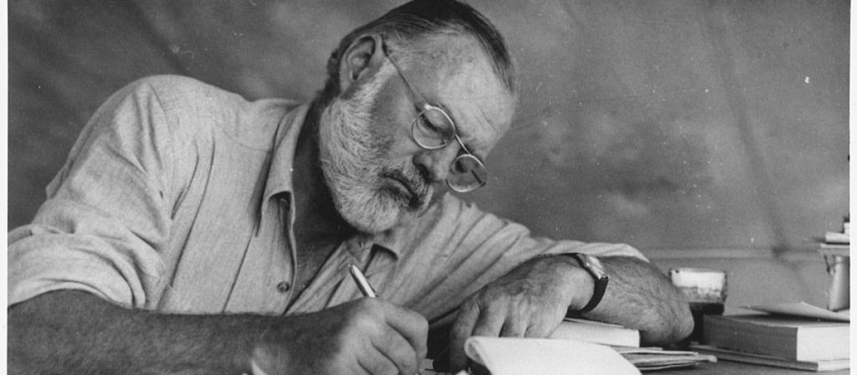 Hemingway escribiendo en un campamento en Kenia, hacia 1953