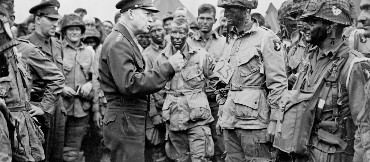 El general Eisenhower dando instrucciones el 5 de junio de 1944 a paracaidistas estadounidenses del 502.º Regimiento Paracaidista (101.ª División Aerotransportada) a punto de participar en el Día D saltando en Normandía esa misma noche
