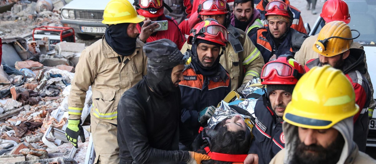 Miembros de un equipo de rescate transportan a una superviviente del terremoto