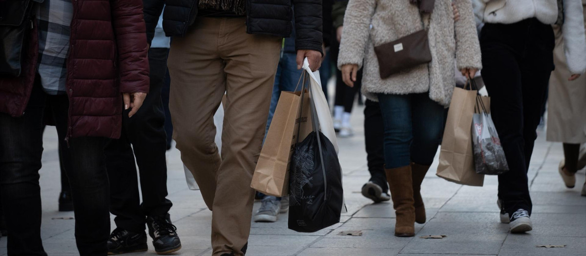 Varias personas realizan sus compras navideñas en la avenida de la Puerta del Ángel, a 9 de diciembre de 2022, en Barcelona.