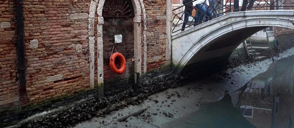 Un canal interno durante una marea baja en Venecia, Italia