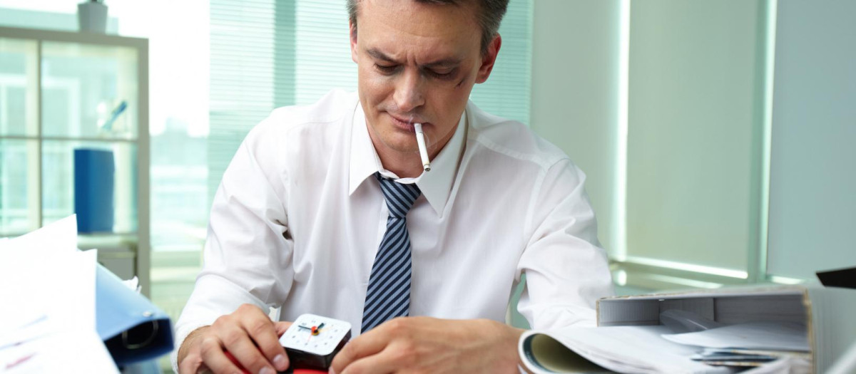 Un hombre se fuma un cigarrillo