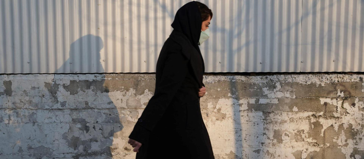 Una mujer cubierta con un velo camina por una calle de Teherán (Irán)