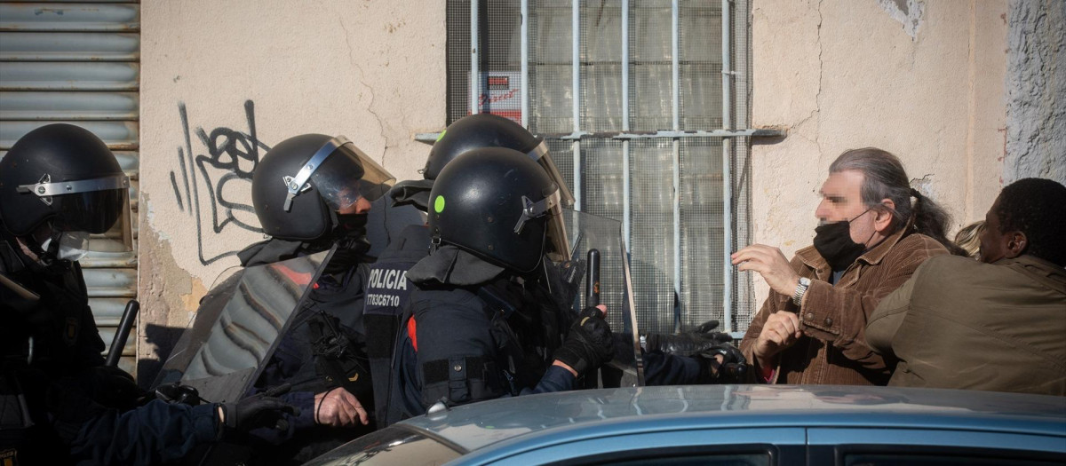 Varias personas intentan evitar el desalojo por parte de la policía de una nave industrial Okupada en Badalona.