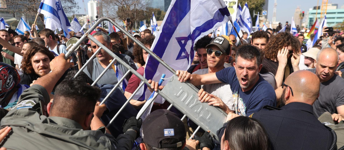 La policía retiene a los manifestantes que bloquean la carretera Ayalon en el centro de la ciudad durante una protesta antigubernamental en Tel Aviv, Israel