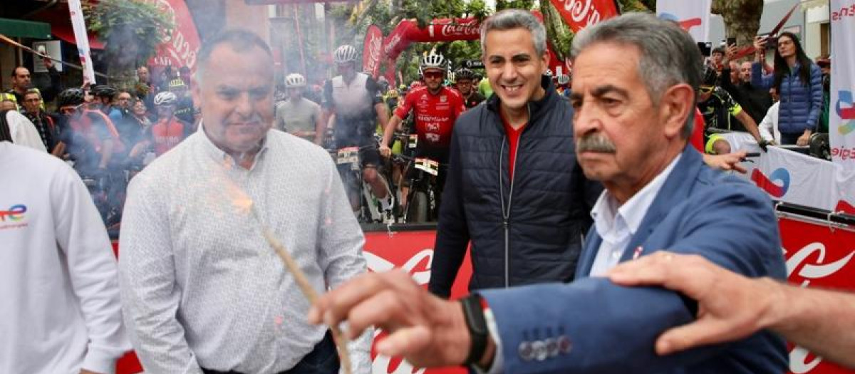 Revilla sostiene una mecha bajo la atenta mirada del vicepresidente cántabro, en marzo de 2022