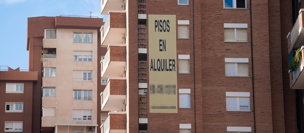 Cartel de alquiler de viviendas en la fachada de un edificio en Barcelona.