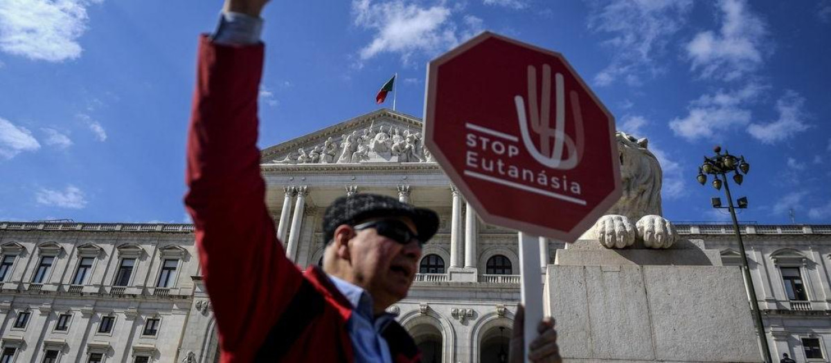 Un hombre en contra de la eutanasia sostiene una pancarta