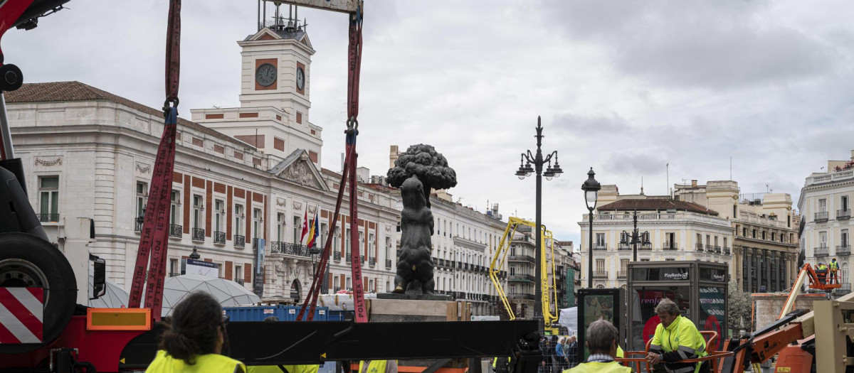 La estatua del Oso y el Madroño ha sido trasladada este viernes a su nueva ubicación en el marco de las obras de remodelación de la Puerta del Sol. La icónica escultura ocupará a partir de ahora el extremo oriental de la nueva alineación de bancos situada en el arco norte de la plaza, a escasos metros de donde se situaba hasta el momento. EFE/ Fernando Villar