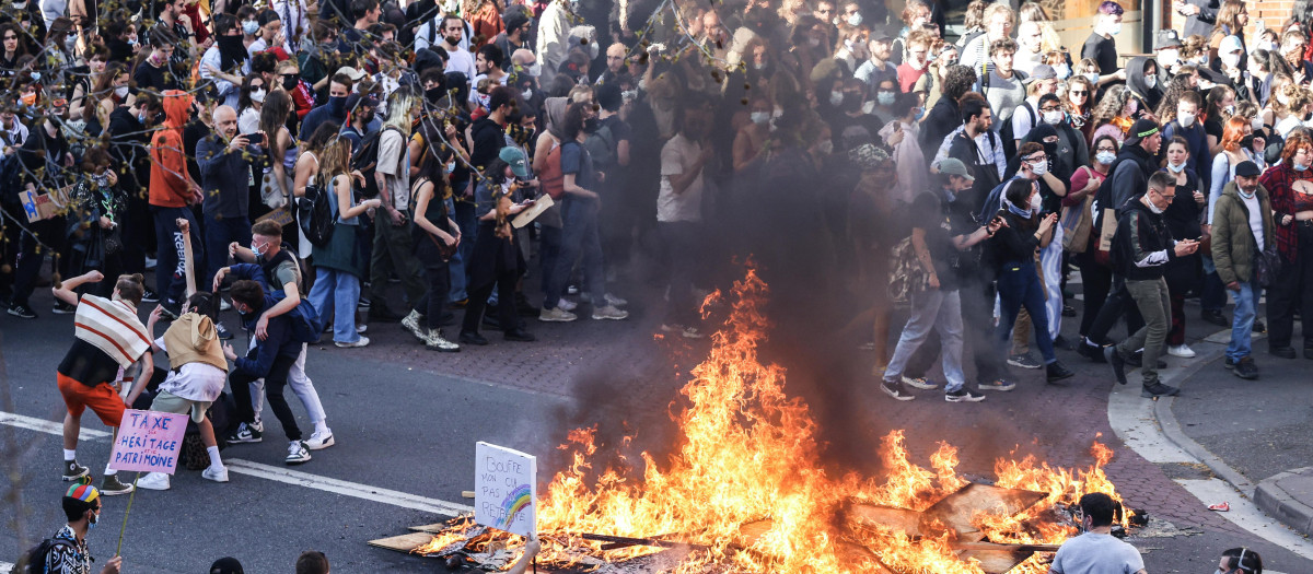 Protesters gather around a fire during a demonstration after the government pushed a pensions reform through parliament without a vote, using the article 49.3 of the constitution, in Toulouse, southern France, on March 28, 2023. - France faces another day of strikes and protests nearly two weeks after the president bypassed parliament to pass a pensions overhaul that is sparking turmoil in the country, with unions vowing no let-up in mass protests to get the government to back down. The day of action is the tenth such mobilisation since protests started in mid-January against the law, which esi:includes raising the retirement age from 62 to 64. (Photo by Charly TRIBALLEAU / AFP)