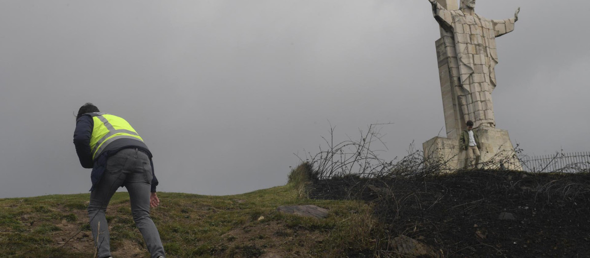 Un miembro de la Policía Científica filma la zona arrasada por el fuego en la cima del Monte Naranco