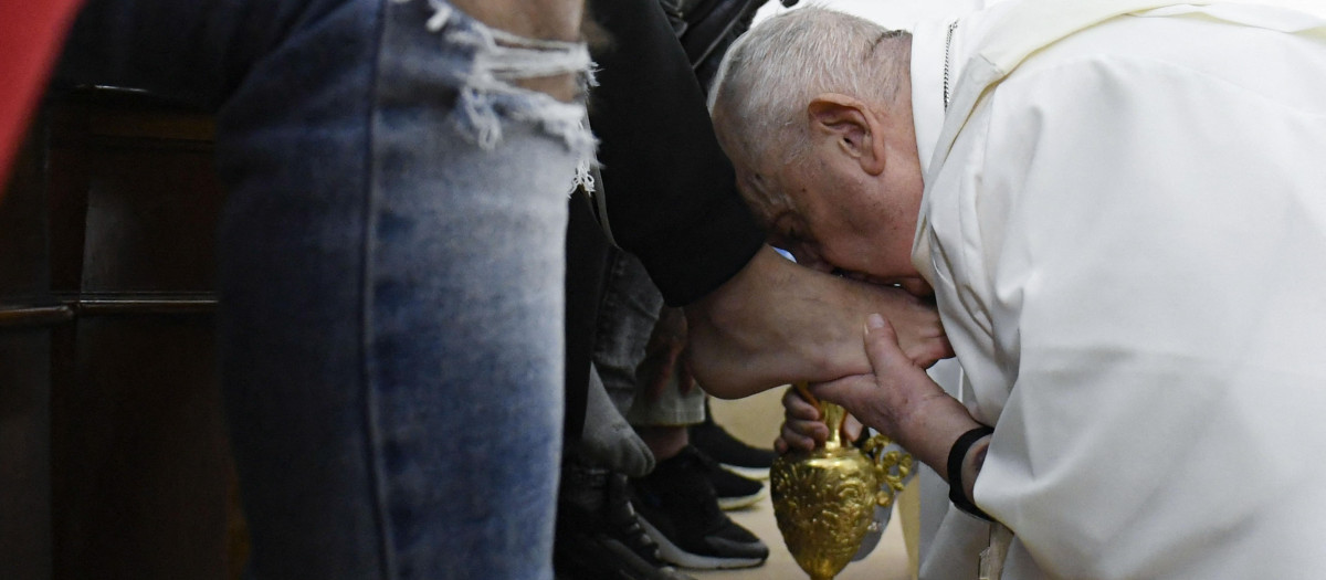 This photo taken and issued as a handout on April 6, 2023 by the Vatican Media shows Pope Francis kissing the foot of a detainee, while performing the "Washing of the Feet" of twelve young detainees at the "Casal del Marmo" Penal Institute for minors in Rome, as part of celebrations of the Holy Week. (Photo by Handout / VATICAN MEDIA / AFP) / RESTRICTED TO EDITORIAL USE - MANDATORY CREDIT "AFP PHOTO / VATICAN MEDIA" - NO MARKETING NO ADVERTISING CAMPAIGNS - DISTRIBUTED AS A SERVICE TO CLIENTS