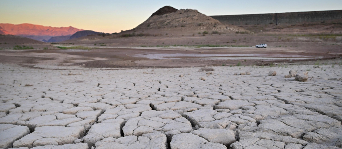 Un vehículo pasa por el lecho de un lago seco y agrietado afectado por la sequía en Boulder City, Nevada