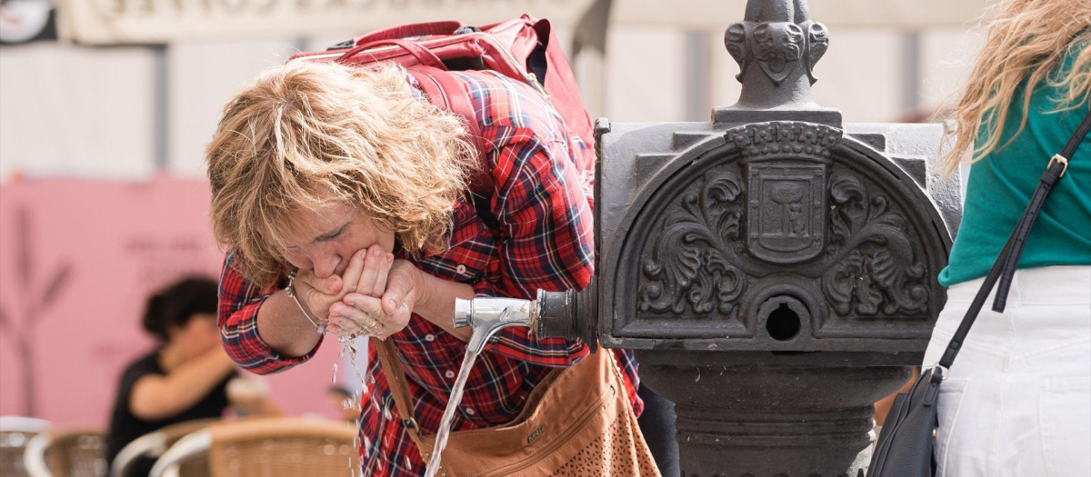 Una mujer bebe agua en Madrid