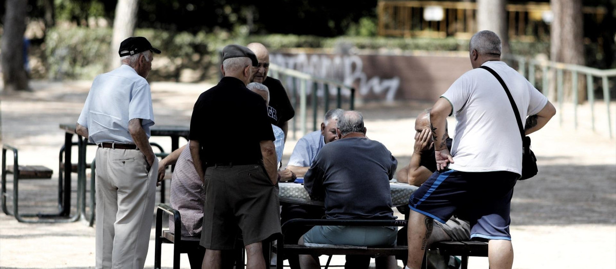 Varios pensionistas juegan al dominó en un parque de Madrid.