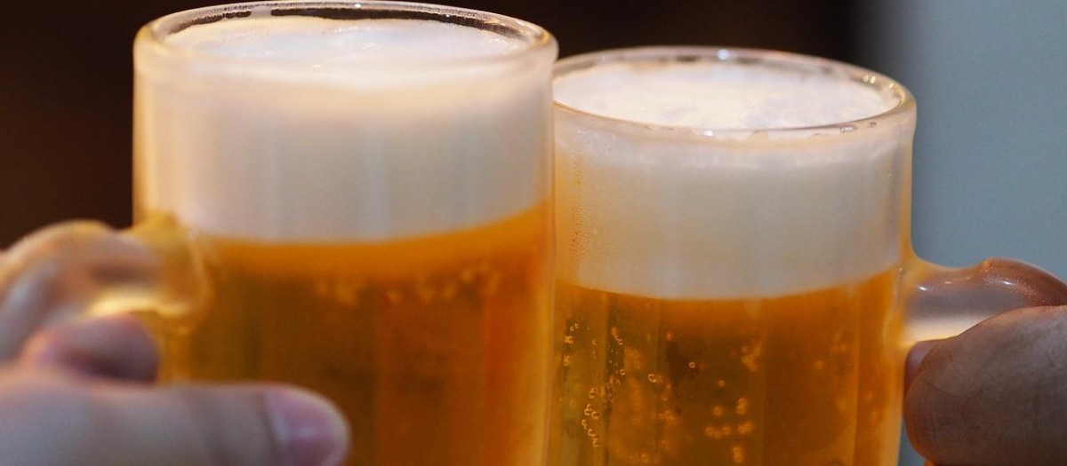Dos personas brindan con cerveza