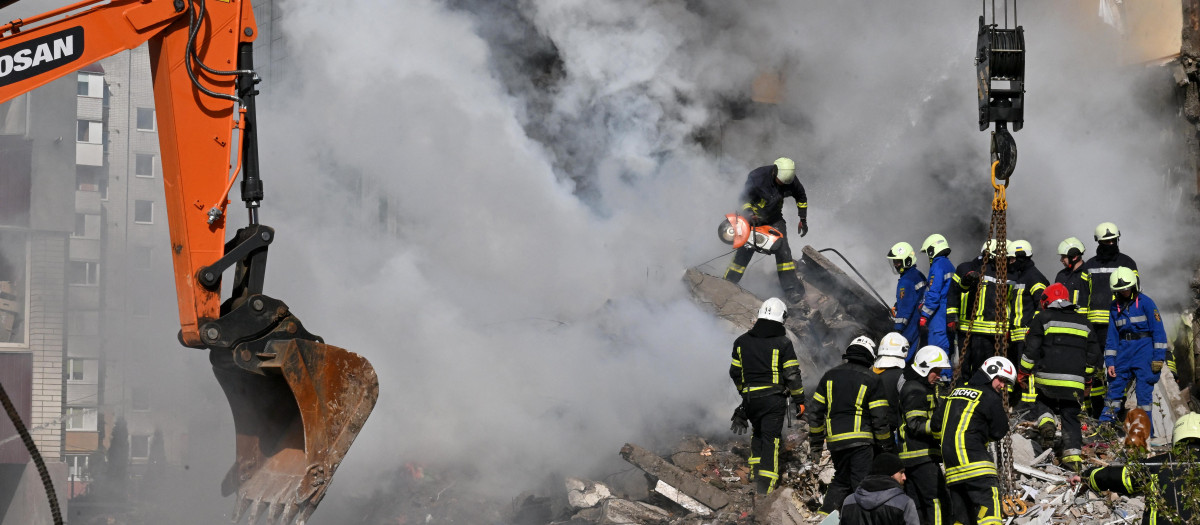 Los equipos de rescate buscan supervivientes entre los escombros de un edificio residencial destruido en Uman
