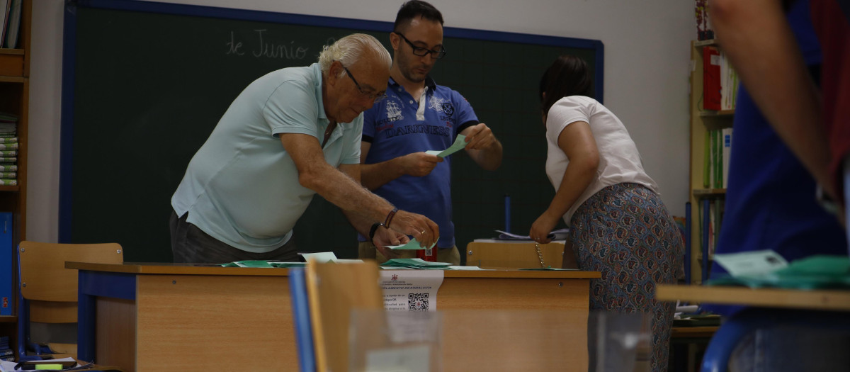 Vocales y presidente contando los votos en una mesa electoral