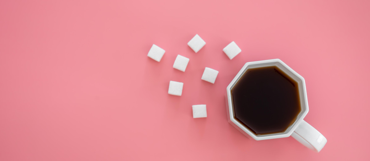 Taza de café acompañada de edulcorantes