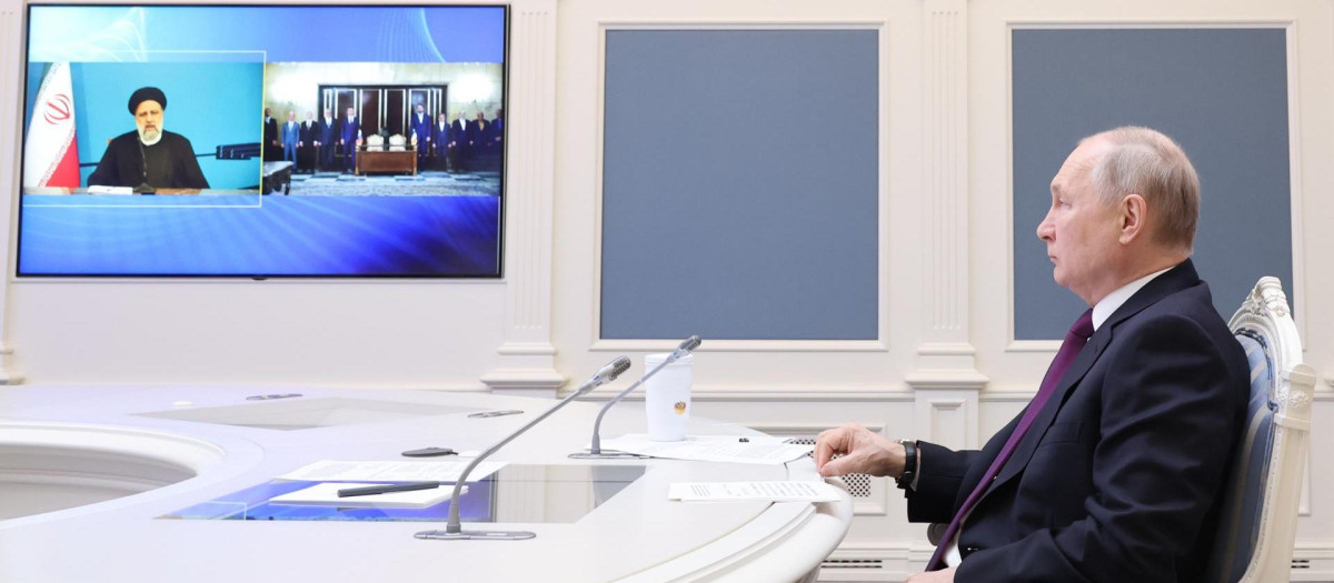 Vladimir Putin, junto al presidente de Irán, Ebrahim Raisi (en pantalla) durante el anuncio de un acuerdo para la construcción de la vía férrea