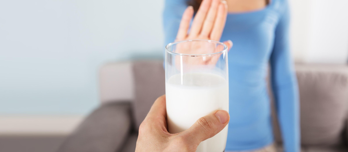 Close-up Of A Woman Rejecting Glass Of Milk At Home